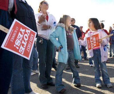 
 Six-year-old Mekenzie Reinbold, center, and  Kamryn Nead, 5,  gather with  school bond supporters  Saturday. The girls attend University Elementary. 
 (Ingrid Lindemann / The Spokesman-Review)