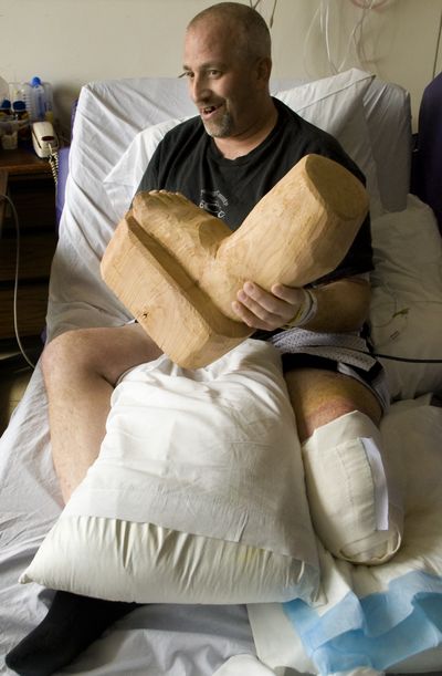 Tim Michaels, who lost part  of his leg in a grain elevator accident near Farmington Wash., Feb 23,2010, holds a wooden foot  carving a relative brought him during his stay at Providence Sacred Heart Medical Center Monday March 8, 2010. (Colin Mulvany / The Spokesman-Review)
