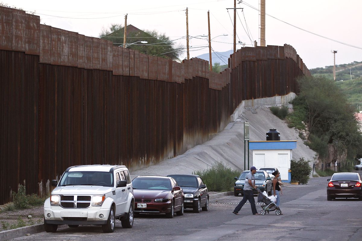 In this Aug. 9, 2012, photo, vehicles are parked along the border fence as pedestrians cross the street in Nogales, Mexico. The location is near the site where a U.S. Border Patrol agent being pelted with rocks opened fire toward Mexico, killing a 16-year-old boy. The shooting has prompted renewed outcry over the Border Patrol�s use-of-force policies and angered human rights activists and Mexican officials who believe the incident has become part of a disturbing trend along the border _ gunning down rock-throwers rather than using non-lethal weapons. (Ross Franklin / Associated Press)
