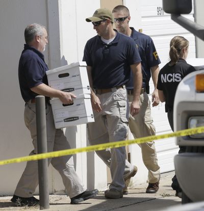 Federal agents carry boxes out of Arc Electronics Inc. on Wednesday in Houston. (Associated Press)