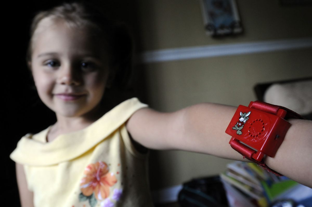 Leilani Santiago, 3, shows off a Wee-Minder “watch,” a potty-training device invented by her mother, Heidi Santiago. The device is part of a kit with a book and DVD. (PHOTOS BY JESSE TINSLEY / The Spokesman-Review)