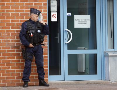 A police officer stands guard outside a polling station for the first-round presidential election in Henin-Beaumont, northern France, Sunday, April 23, 2017. (Frank Augstein / Associated Press)