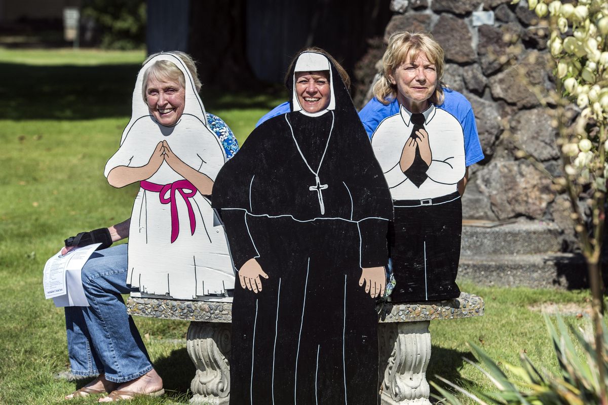 From left,  Charlotte Mangan, Elaine George and Cindy Koker gather behind a cutout that can be used for pictures during St. Paschal Parish’s  centennial celebration, which takes place Saturday and Sunday. (Dan Pelle / The Spokesman-Review)