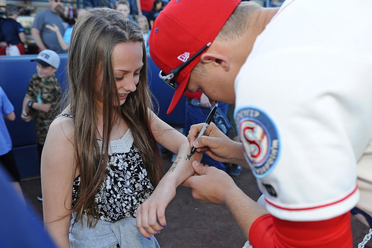 Summer Morkus, left, gets her arms autographed by Spokane Indians pitcher Scott Engler  before a game against the Boise Hawks at Avista Stadium on  June 15. (James Snook / SR)