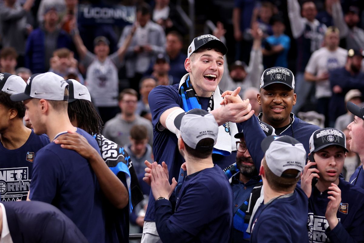 Connecticut's Donovan Clingan, top middle, celebrates with teammates after a 77-52 win against Illinois in the Elite 8 round of the NCAA Tournament at TD Garden on Saturday, March 30, 2024, in Boston.   (Tribune News Service)