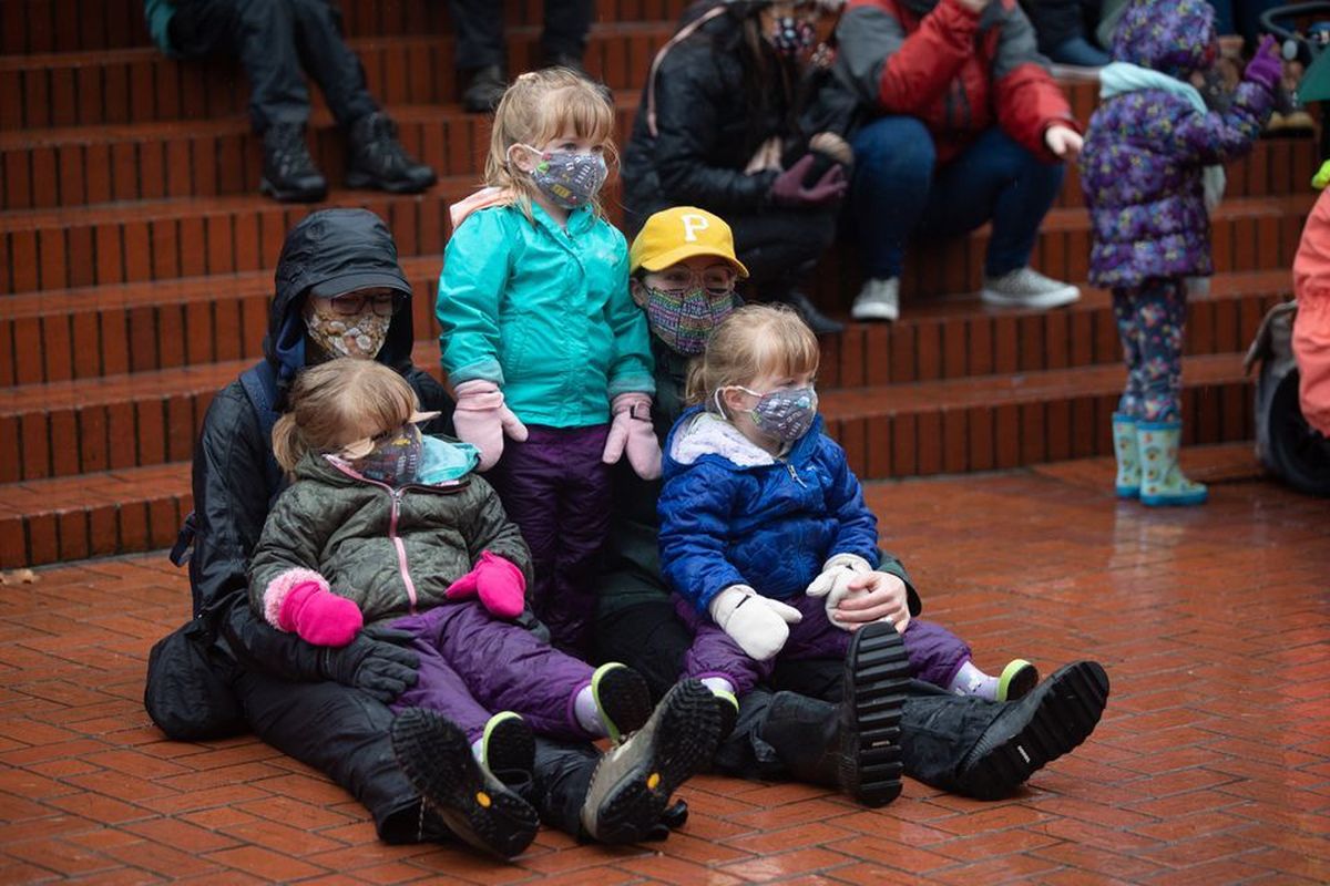 Far left: Despite wind and rain, young onlookers sit before the 30th annual Tuba Christmas concert at Pioneer Courthouse Square in Portland.  (Mark Graves/Oregonian)