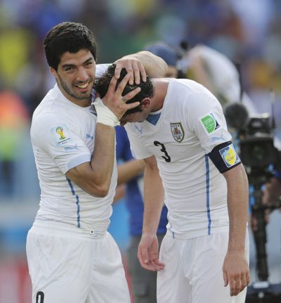 Uruguay's Luis Suarez, left, celebrates with Diego Godin following their 1-0 win over Italy on Tuesday. (Associated Press)