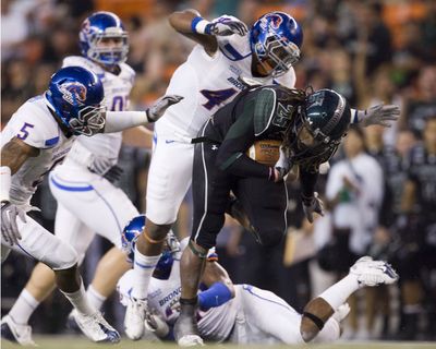 Hawaii running back Alex Green is brought down by Daron Mackey and other Boise State defenders. The Broncos forced six turnovers, leading to 30 points.   (Associated Press / The Spokesman-Review)
