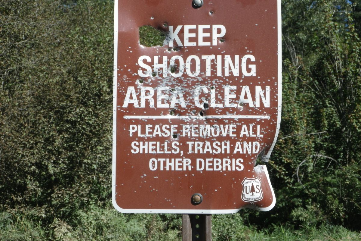 Signs posted by the Idaho Panhandle National Forests requesting that shooters be responsible for cleaning up their mess at a target shooting site near Hayden Creek were destroyed by gunfire within a few months during the summer of 2013.   (U.S. Forest Service)