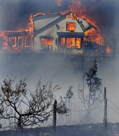 A home burns just north of East River Road in the Pine Creek Fire Wednesday near Livingston, Mont. (Associated Press)