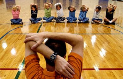 
Physical Education teacher David Hirsch, front leads a class of third-graders through a series of stretches during class Tuesday at Seltice Elementary. The Idaho education department held a public meeting Tuesday night about increasing K-12 physical education requirements. 
 (Kathy Plonka / The Spokesman-Review)