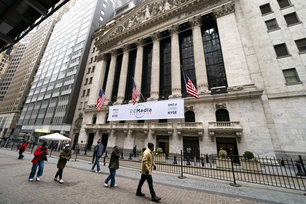 Pedestrians pass the New York Stock Exchange, Wednesday, Jan. 27, 2021, in New York. Major indexes opened lower on Wall Street Friday, Jan. 29, while shares of GameStop, AMC and several other stocks being targeted by a rowdy community of amateur investors soared again.  (Associated Press)