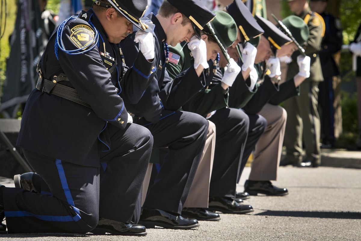 During the Bell Salute, honor guard officers take a knee in front of the Law Enforcement Officers Memorial Project at the 31st Annual Law Enforcement Ceremony on Tuesday, May 15, 2018, next to the Public Safety Building in Spokane. (Colin Mulvany / The Spokesman-Review)