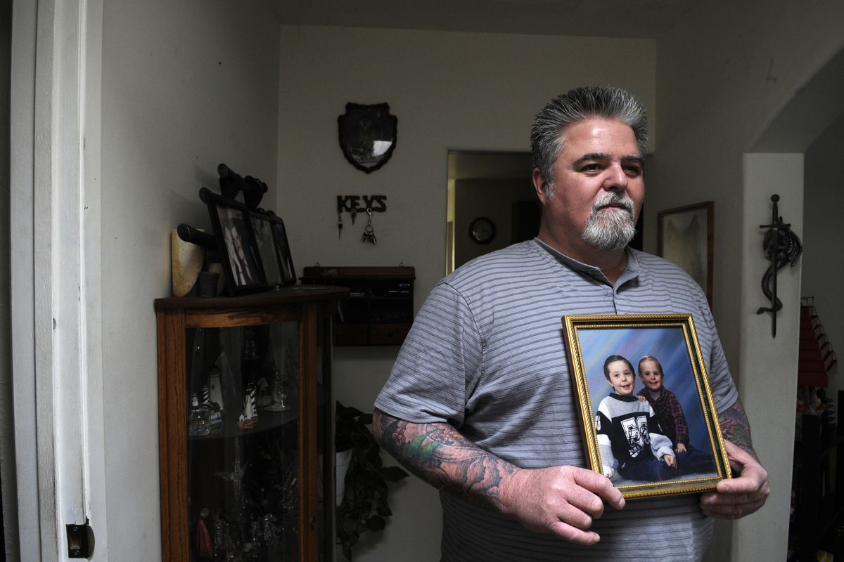 Bill Connington, of Spokane, holds a portrait that he has kept hanging  in his house since his ex-wife took his two sons and left the area almost 12 years ago. He received word in late December that law enforcement had located his ex-wife and the boys were  in foster care. (Jesse Tinsley)