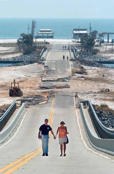 
Local residents Bruce and Jennifer Ehrenberger walk back over a bridge to the mainland Saturday after checking on their home in Navarre Beach, Fla. 
 (Associated Press / The Spokesman-Review)