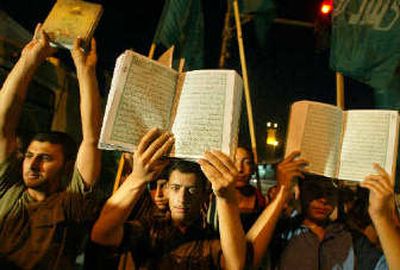 
Supporters of the Islamic group Hamas display copies of the Quran, the Muslim holy book, during a demonstration in Gaza City on Wednesday. The protest was against alleged desecration of several copies of the Quran by Israeli soldiers during a search inside prison cells of Palestinian inmates. 
 (Associated Press / The Spokesman-Review)