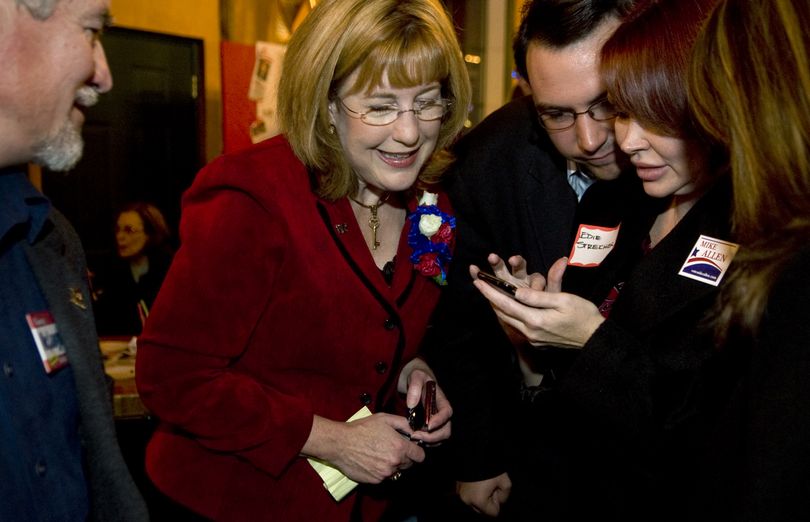 Spokane City Councilwoman Nancy McLaughlin checks early returns on Edie Streicher’s cell phone at the Bangkok Thai restaurant on East Trent Avenue. (Colin Mulvany / The Spokesman-Review)