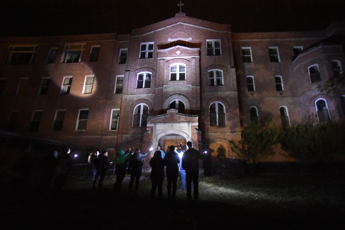 People gather outside the shuttered St. Ignatius Hospital before taking the Haunted Hospital tour sponsored by the Colfax Chamber of Commerce, Thursday, Oct. 6, 2016, in Colfax, Wash. (Colin Mulvany / The Spokesman-Review)