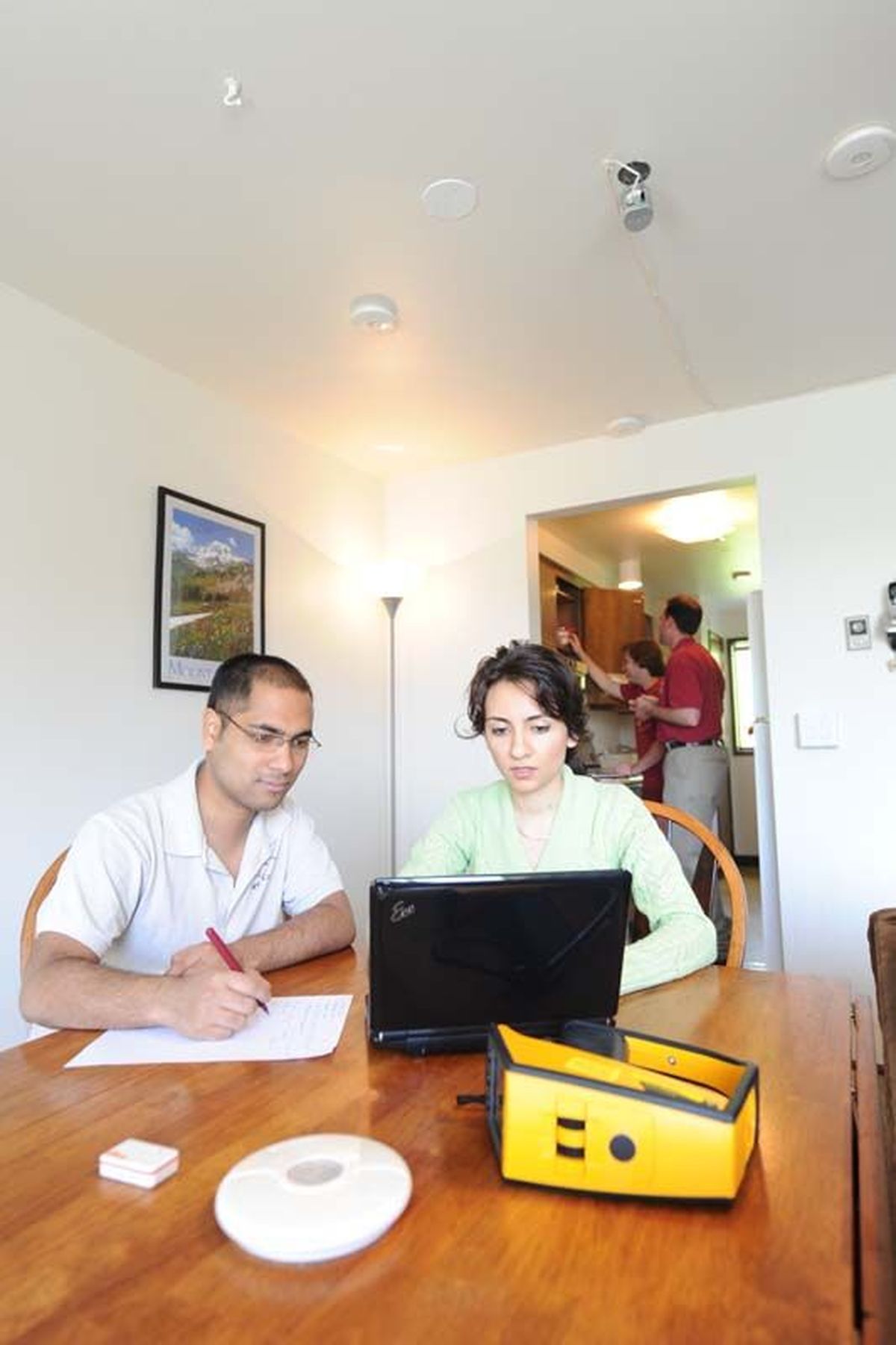 Former students in the WSU School of Electrical Engineering and Computer Science work to install smart devices in a campus test apartment at WSU in Pullman.  (Courtesy of WSU)