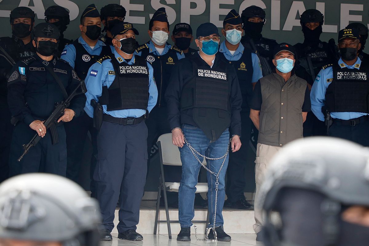 Former Honduran President Juan Orlando Hernandez, center in chains, is shown to the press at the Police Headquarters in Tegucigalpa, Honduras, Tuesday, Feb. 15, 2022. Police arrested Hernandez at his home, following a request by the United States government for his extradition on drug trafficking and weapons charges. (Elmer Martinez)