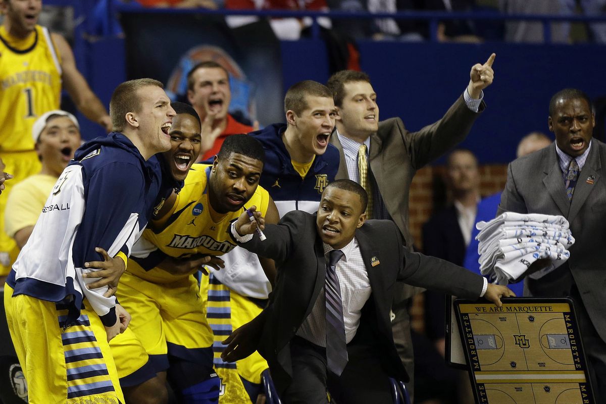 The Marquette bench erupts after a late basket in the second half help the Golden Eagles hold off the Butler Bulldogs. (Associated Press)