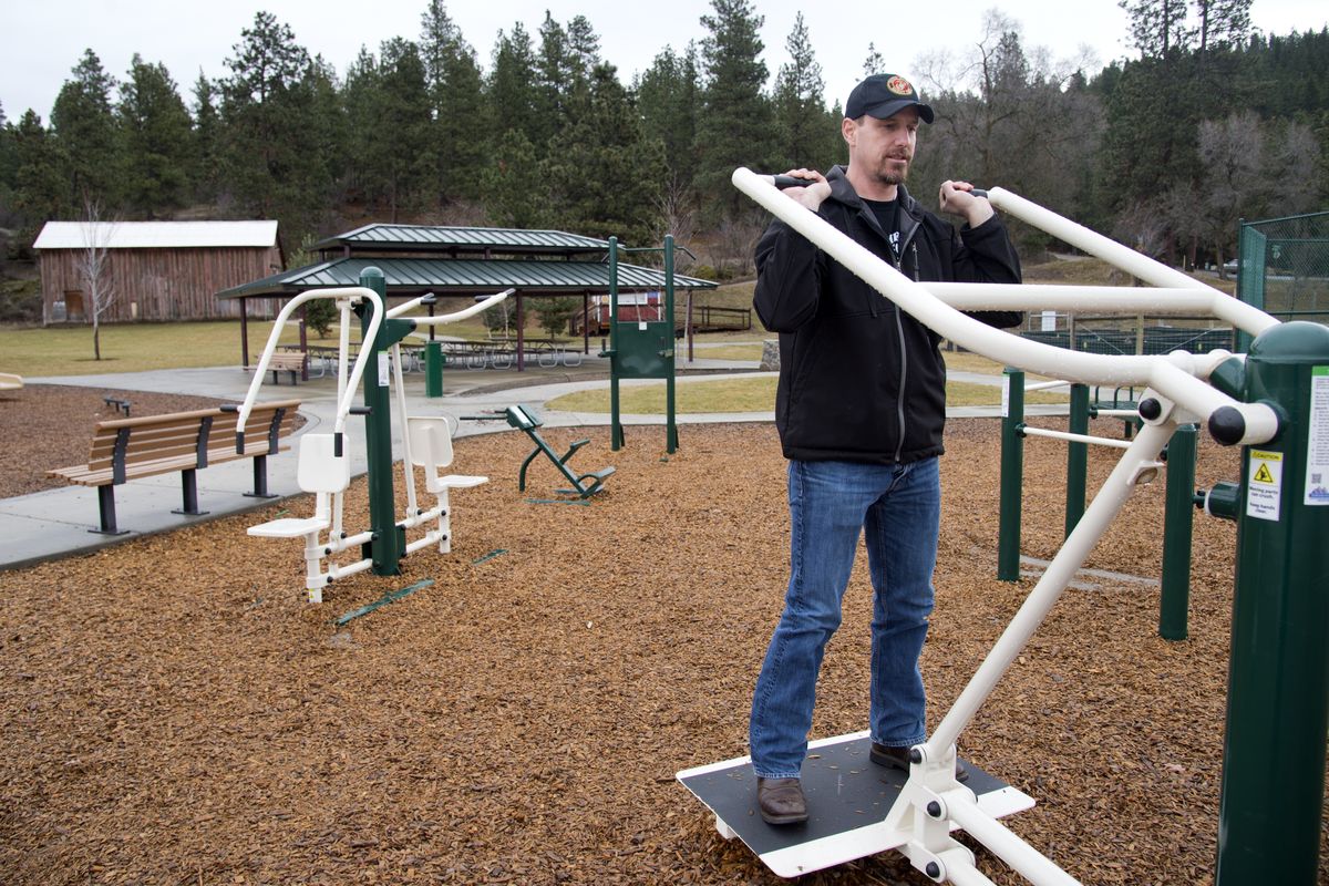 Bob Wiese, project manager for a series of fitness stations at parks in Liberty Lake, demonstrates one of the machines that use a person’s body weight for resistance Feb. 5 at Rocky Hill Park. Three of five fitness stations, named to honor the military, have been installed, and two more will be added at parks around town. (Jesse Tinsley)