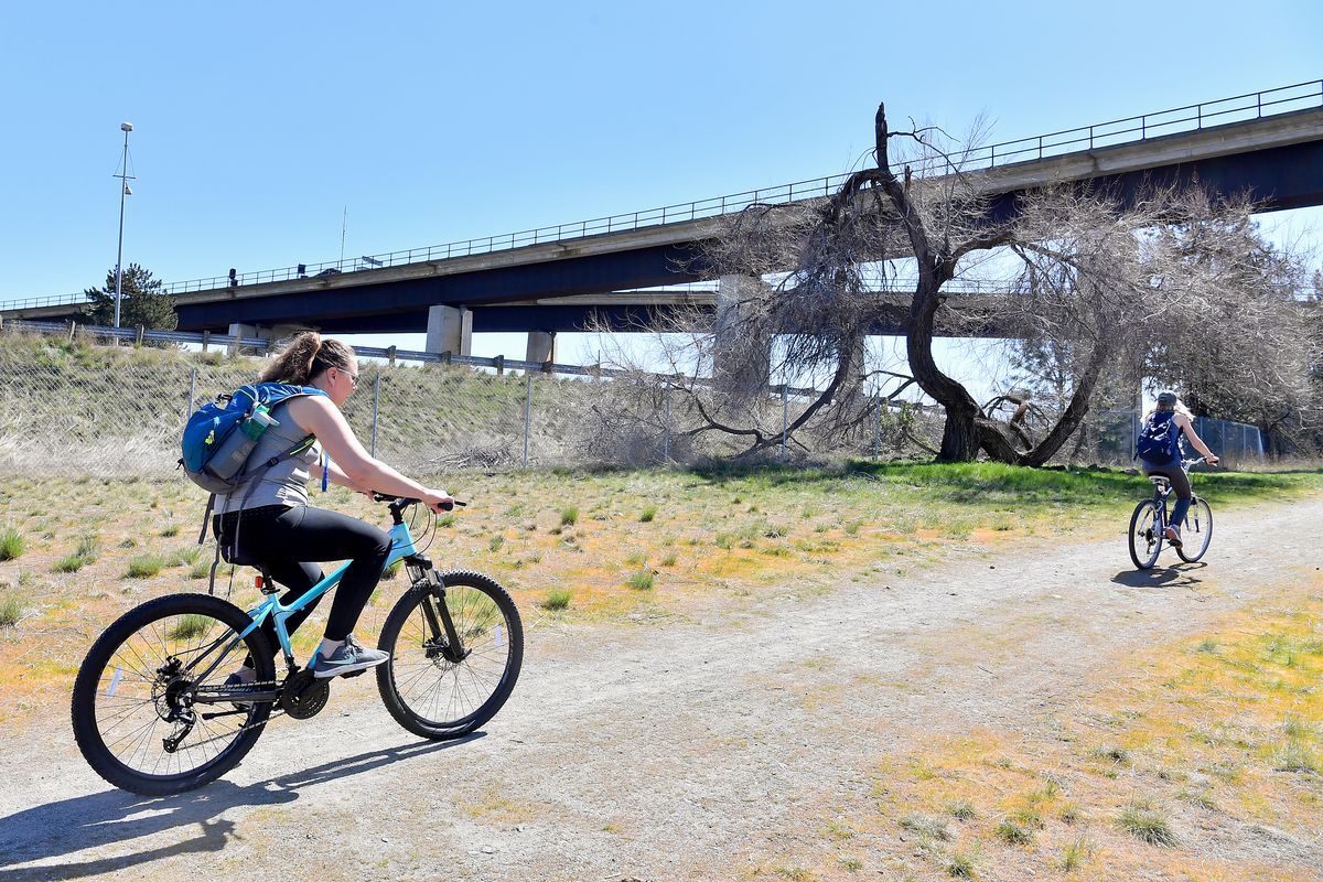 Ammie Hawk, left, and her sister Sarah Frey set out on a bicycle ride Saturday at Fish Lake Trailhead in Spokane.  (Tyler Tjomsland/The Spokesman-Re)
