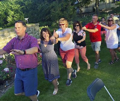 In this Saturday, July 7, 2018, photo provided by the Leah for Senate campaign, Wisconsin state Sen. Leah Vukmir, a candidate for the U.S. Senate, gives a thumbs up while taking part in a conga line with Gov. Scott Walker, left, during a party at the executive residence in Madison, Wis. (Leah for Senate campaign via AP) ORG XMIT: CER101 (AP)