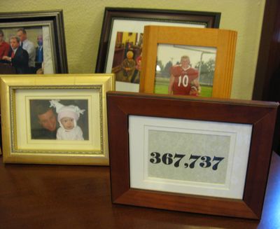 A plaque that says “367,737” sits among pictures behind Idaho Attorney Lawrence Wasden’s desk. The plaque show the number of votes Wasden received in the 2010 election. (Betsy Z. Russell / S-R)