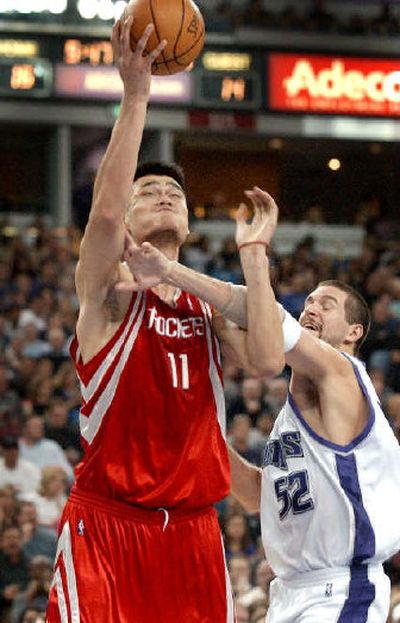 
Rockets center Yao Ming, left, is fouled under the basket by the Kings' Brad Miller. 
 (Associated Press / The Spokesman-Review)