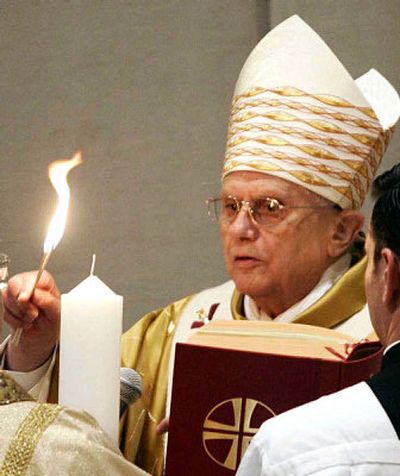 
Pope Benedict XVI lights a candle during the Easter vigil Mass in St. Peter's Basilica at the Vatican on Saturday. 
 (Associated Press / The Spokesman-Review)