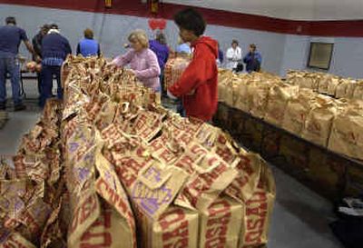 
David Williams carries an armful of food to the distribution table in the gym at the Salvation Army, where turkey and trimmings for 3,500 Thanksgiving dinners were handed out on Tuesday. 
 (Christopher Anderson/ / The Spokesman-Review)