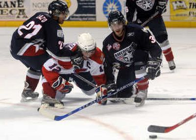Tri-City's Johnny Lazo, left, and Jarrett Toll sandwich Spokane's Chris Bruton as they chase the puck in the second period Monday night.
(Rajah Bose / The Spokesman-Review)