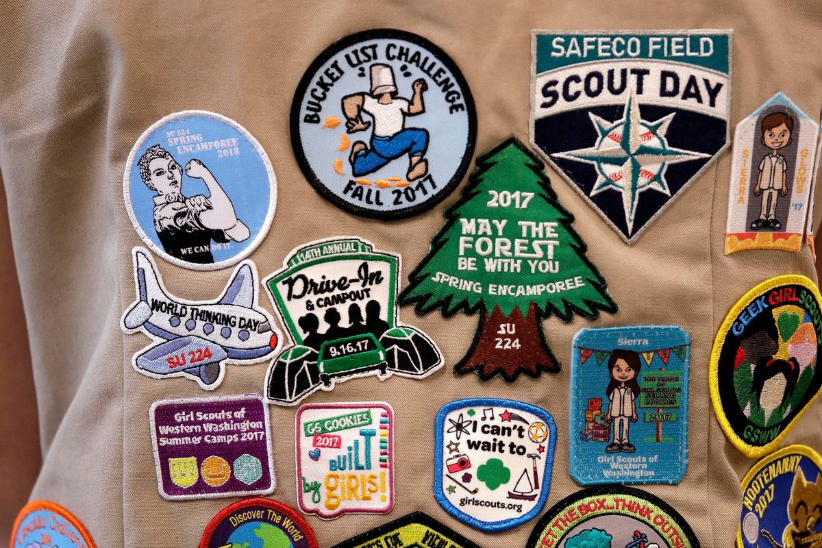 FILE - Patches cover the back of a Girl Scout
