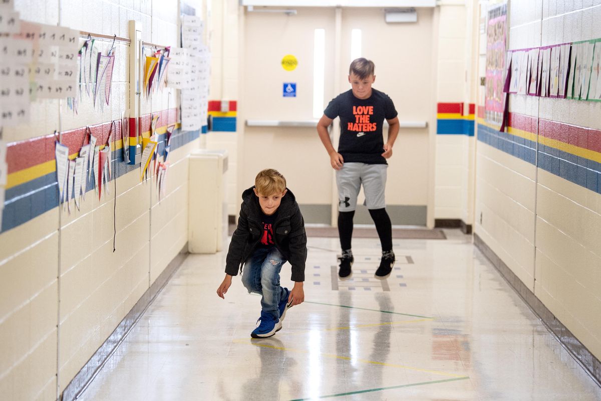 Fourthgrader Ian Butterfield, foreground, and sixthgrader Myles Gibson walk, jump and hop through a course of steps and activities marked on the floor of Balboa Elementary Friday, Sept. 20, 2019 in Spokane.  The activity is designed to help kids focus and concentrate and may be assigned by a teacher or self-assigned when a kid feels unfocused in class. The activity helps kids return to class more ready to focus on class work.  Jesse Tinsley/THE SPOKESMAN-REVIEW (Jesse Tinsley / The Spokesman-Review)