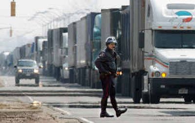 
A Windsor police officer monitors traffic along Huron Church Road in Ontario last year. Most Canadian border crossings are guarded by a lone staffer. 
 (File/Associated Press / The Spokesman-Review)