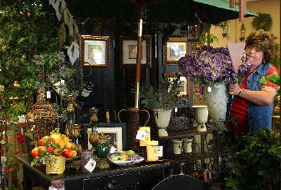 
Heather Nelson, owner of  Olive Branch Home Décor, moves a vase of flowers in her store, which has been open at Bowdish and Sprague for two months. 
 (Liz Kishimoto / The Spokesman-Review)