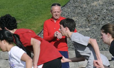 Now: Rick Riley, assistant track coach at St. George’s, times his runners from the starting line during practice last month at Whitworth University.   (Dan Pelle / The Spokesman-Review)