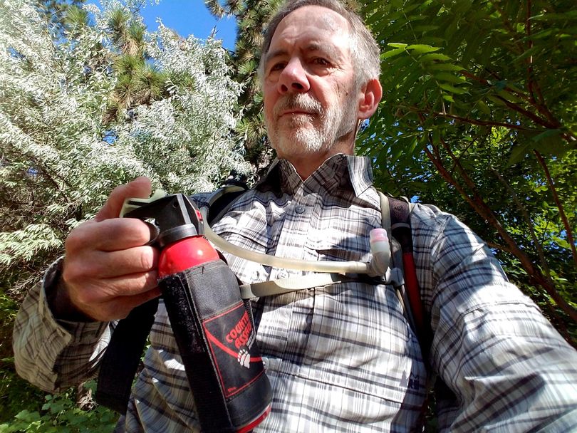 Author Rich Landers holds a canister of bear spray while on a hike. (Rich Landers / The Spokesman-Review)