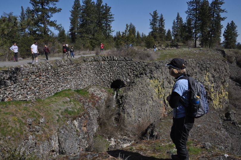 Hikers enjoy the CCC-era stone bridge over a creek on Rimrock Drive in Palisades Park, a Spokane city park established in 1938 and expanded in recent years. (Rich Landers)