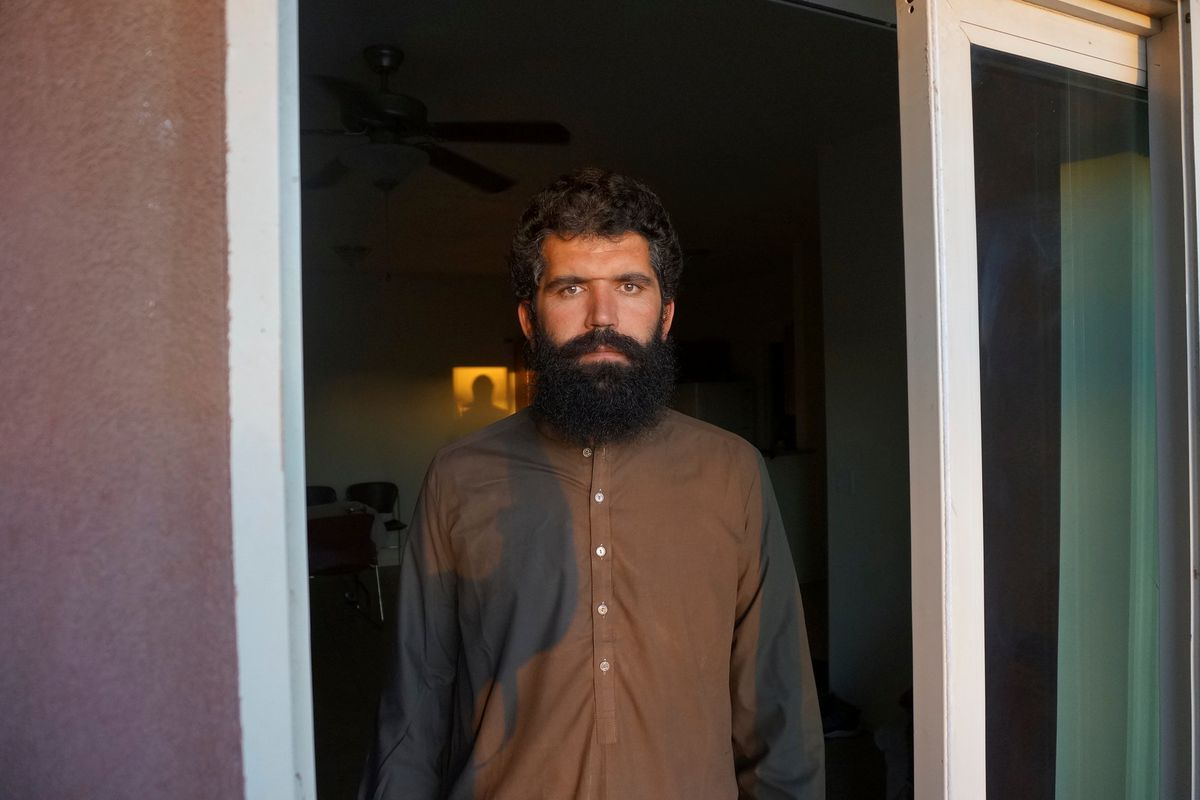 Wolayat Khan Samadzoi watches through the open balcony door of his apartment for the sliver of new moon to appear in the cloudless sky, where the sun had set beyond a desert mountain, in Las Cruces, N.M., Saturday, April 2, 2022. Samadzoi and thousands of other Afghans evacuated to the United States as the Taliban regained power last summer are celebrating their first Muslim holy month of Ramadan here – grateful to be safe, but agonizing over their families back home under the repressive Taliban regime.  (Giovanna Dell