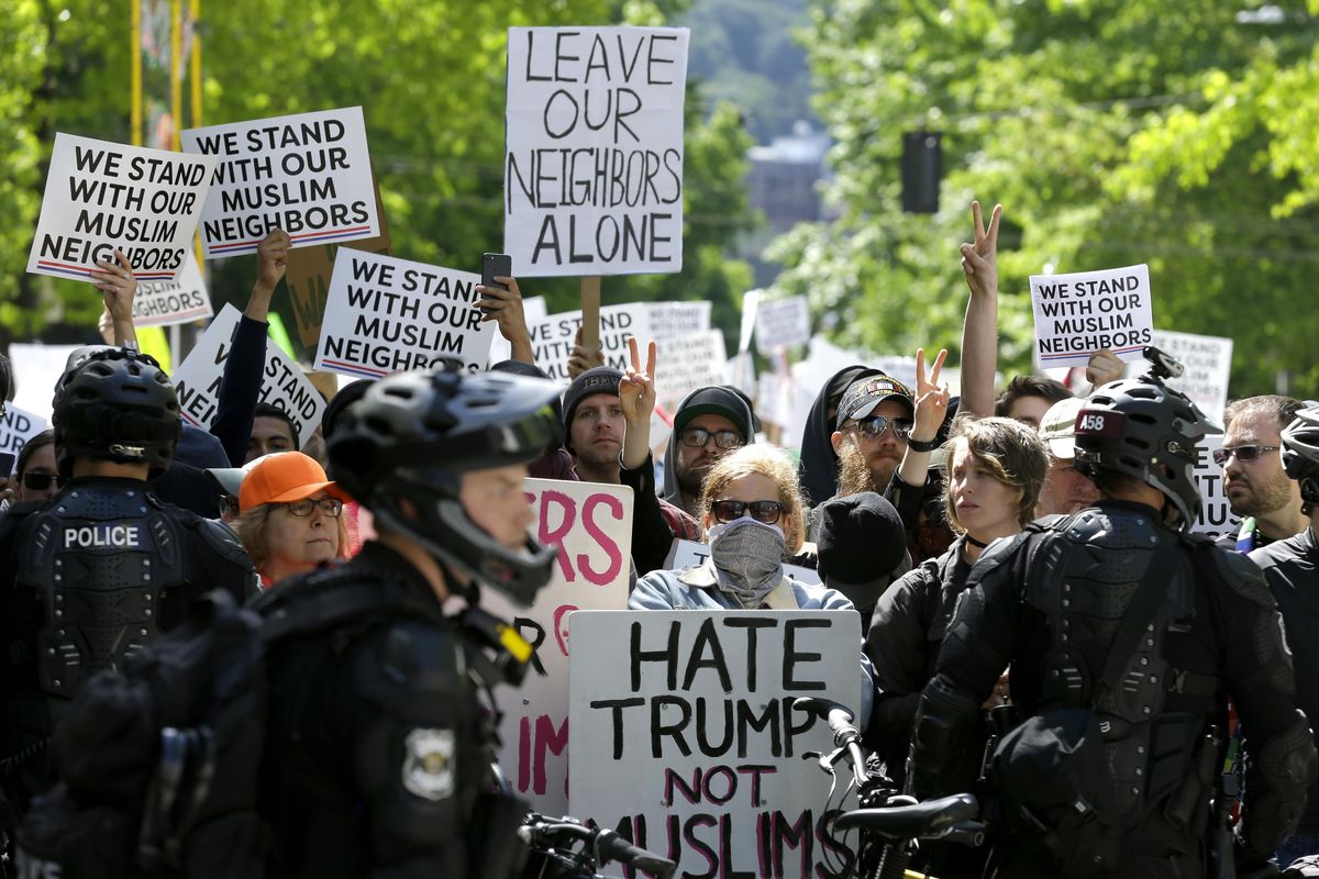 Counter-protestors stand behind a line of Seattle Police officers across the street from an anti-Islamic law protest rally Saturday, June 10, 2017, in Seattle. In more than two dozen cities across the United States, the group organizing the rallies, ACT for America, is speaking out against Shariah law, saying it is incompatible with Western democracy and the freedoms it affords. (Ted S. Warren / Associated Press)