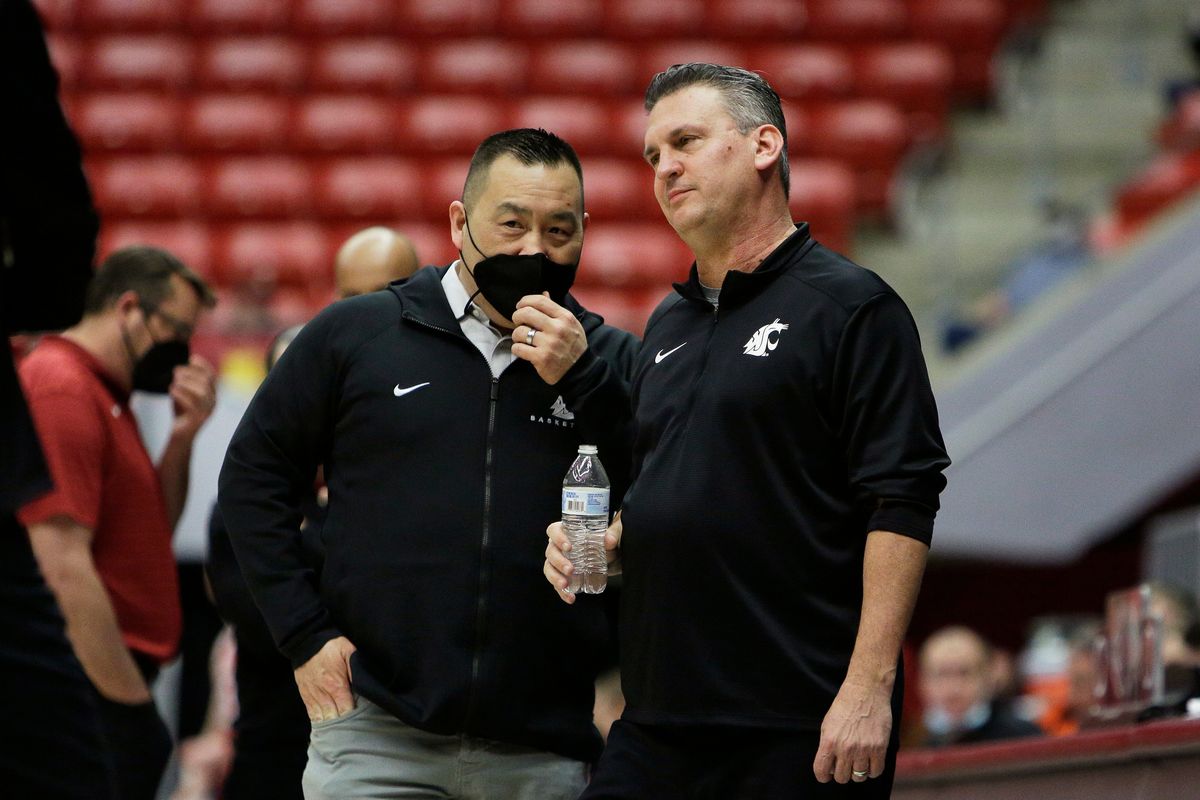 Washington State coach Kyle Smith (right), speaks with school athletic director Pat Chun during a delay before a Pac-12 game against Stanford on Jan. 13 in Pullman.  (Associated Press)