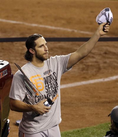 Giants pitcher Madison Bumgarner celebrates with the MVP trophy. (Associated Press)