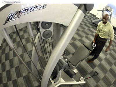 
An employee demonstrates the removable bench feature of the Life Fitness G5 Cable Motion Gym System. Experts advise that before you begin your search for home exercise hardware, first review your commitment to exercising and the type of exercise routine you are doing. 
 (File Photo / The Spokesman-Review)
