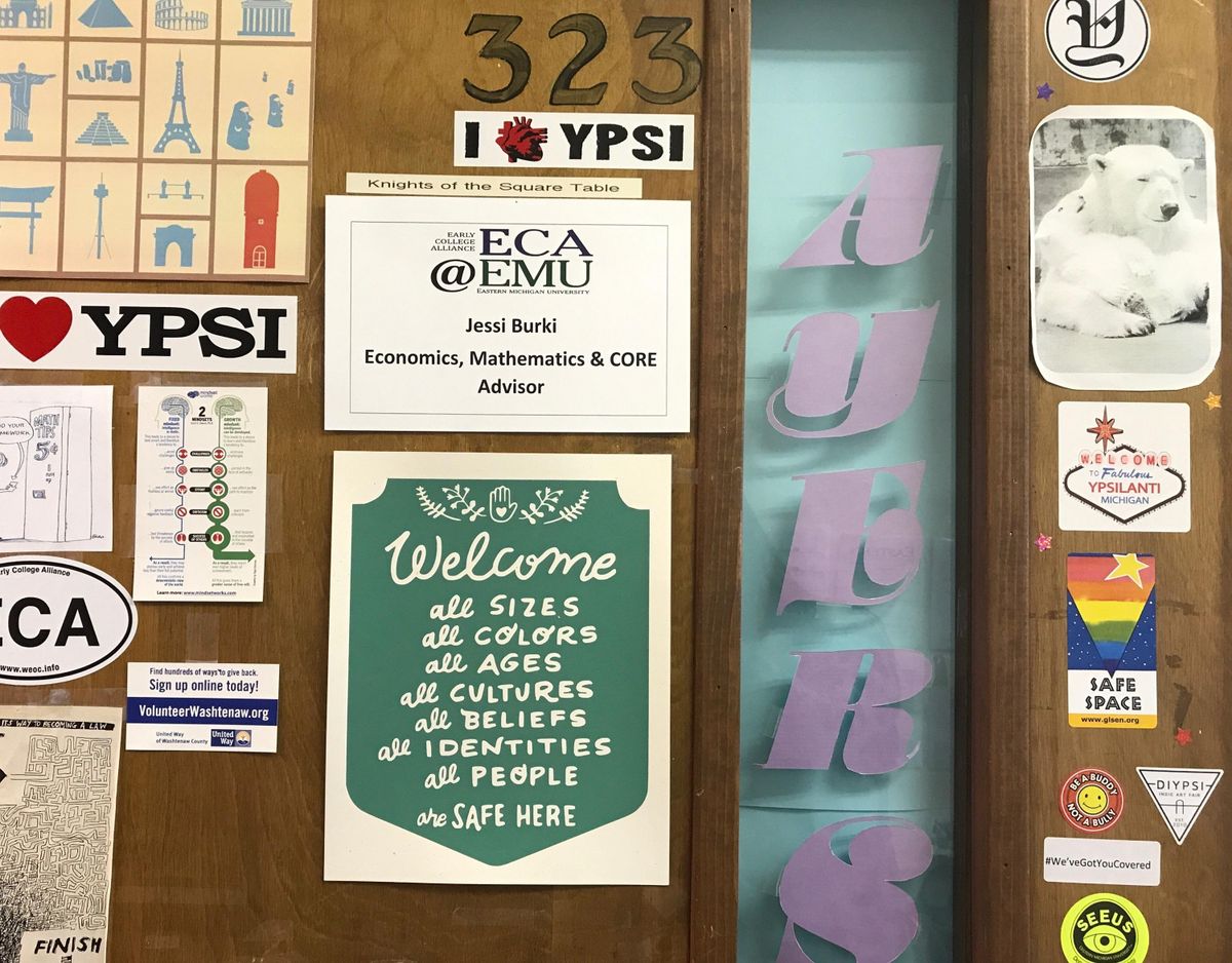 This undated photo shows the "Welcome All" sign, center at bottom, created by Marcy Davy, on a classroom office door at the Early College Alliance on Eastern Michigan University