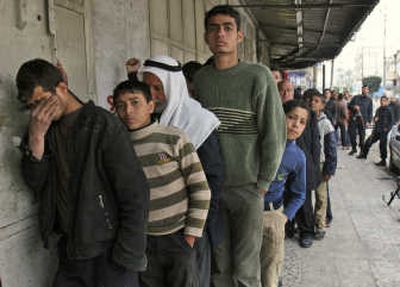 
Palestinians wait in line to buy bread from a bakery in Gaza City on Monday. 
 (Associated Press / The Spokesman-Review)