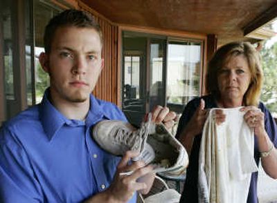
Jason Bunch, 18, holds his lightning-burned shoe and his mother Kelly Risheill his burned shirt Wednesday at their home in Castle Rock, Colo. Bunch was also wearing an iPod when he was struck by lightning last July while mowing the grass at the house.Associated Press photos
 (Associated Press photos / The Spokesman-Review)