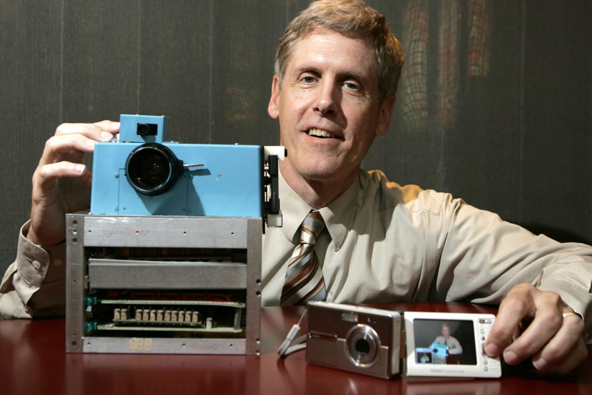 In this 2005 photo, Steven J. Sasson, then Eastman Kodak Co. project manager, shows his prototype digital camera he built in 1975 next to Kodak’s digital camera the EasyShare One. (Associated Press)