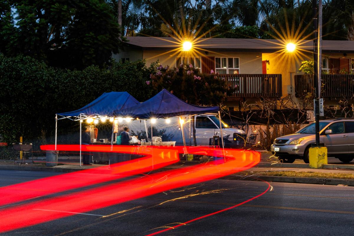 Vehicles whiz by on June 25 as Ricos Tacos Naomi serves a customer on Obama Boulevard in Los Angeles. Mariana Yepez, co-owner of the taco stands, and two other Ricos Tacos Naomi employees are charged with allegedly killing a co-worker. (Gina Ferazzi/Los Angeles Times/TNS)